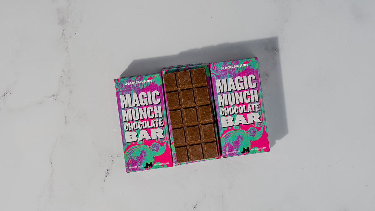 Magic Munch fifteen square chocolate bar placed right next to the chocolate bar's colorful container box